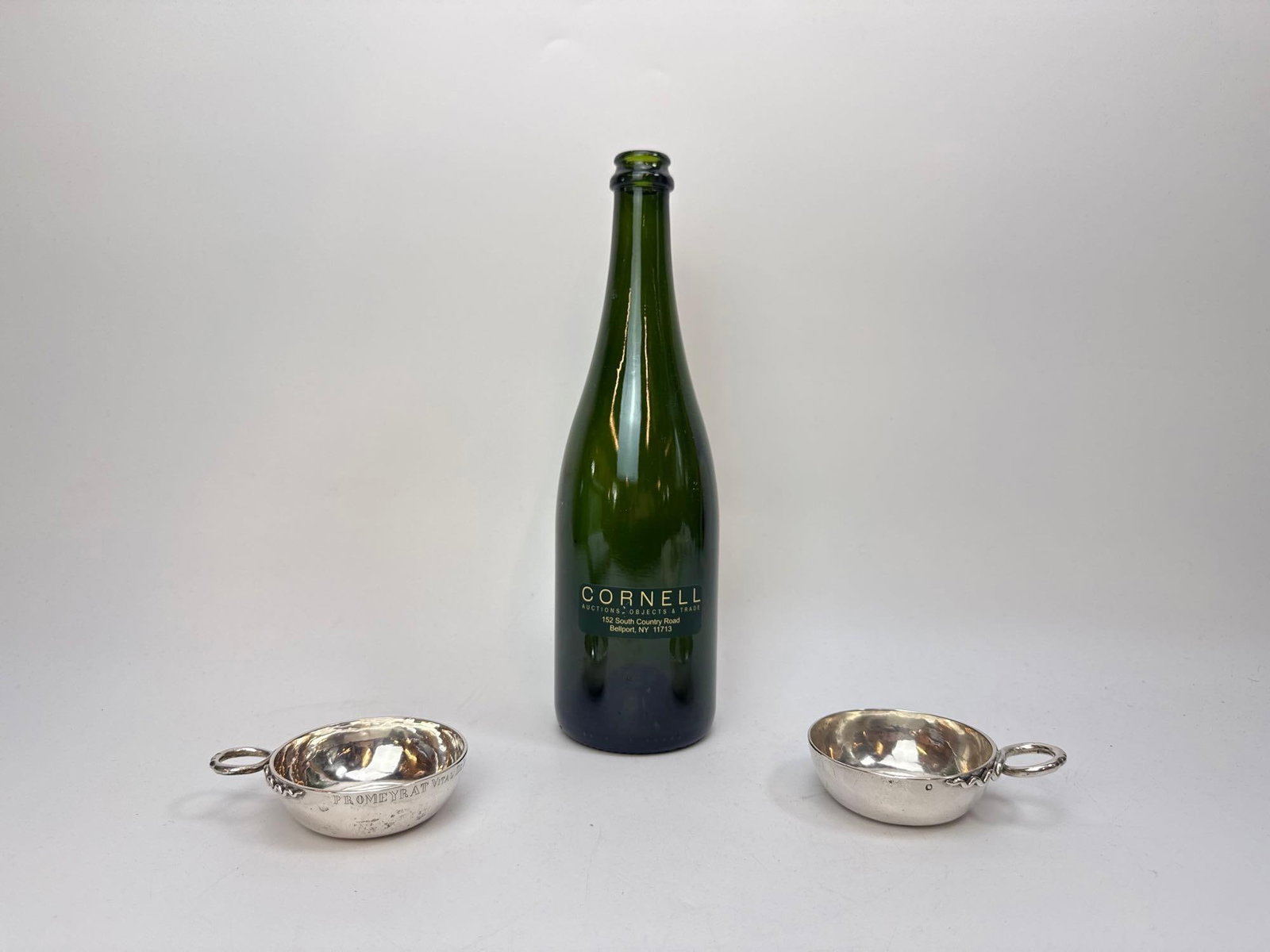 PAIR OF ANTIQUE FRENCH SILVER TASTEVINS, ENGRAVED: Two antique French silver wine tasting cups (tastevins), each of traditional dished form with a raised domed center and an applied ring handle, one engraved around the rim with a name referencing “P