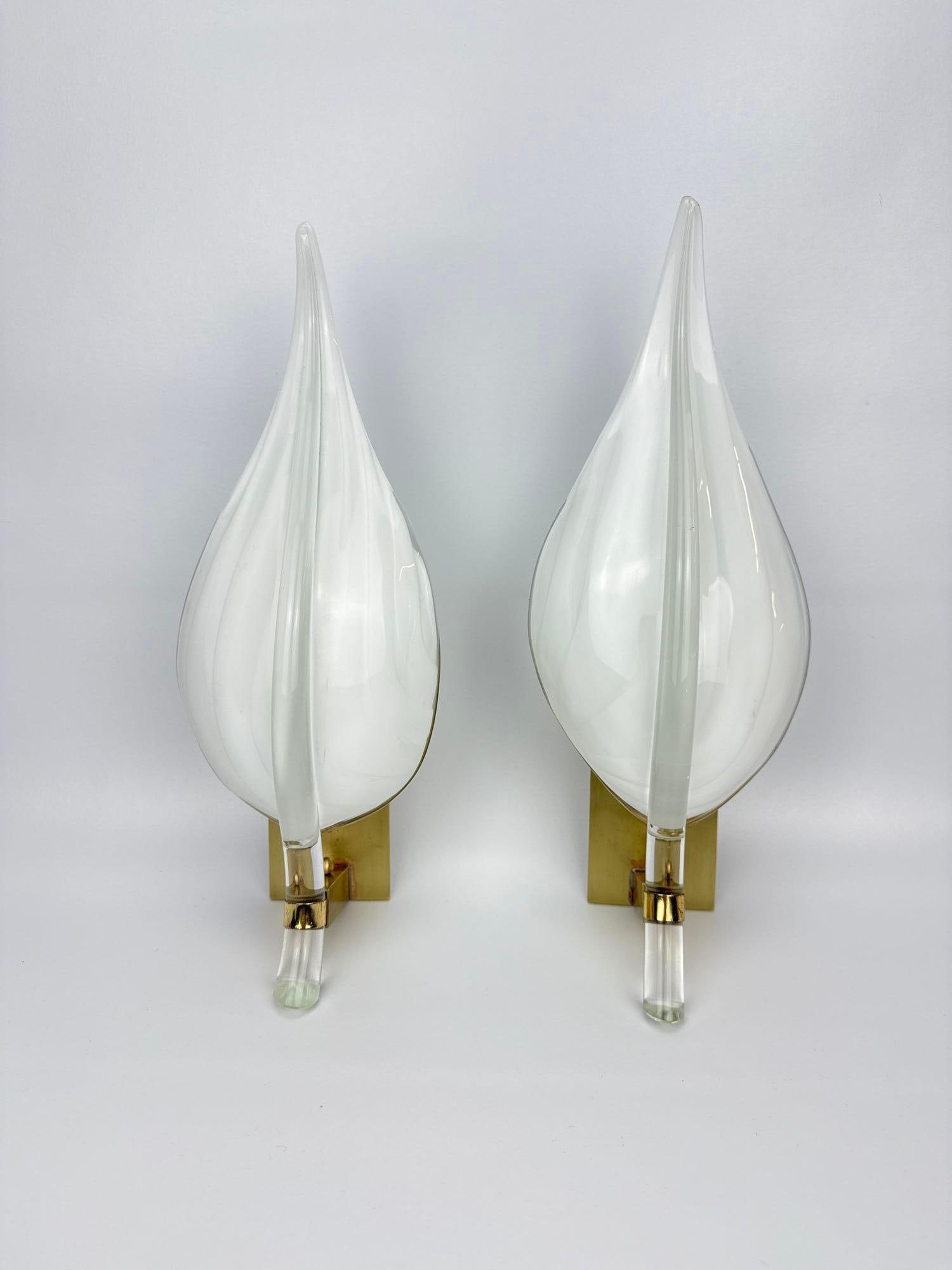 (1 OF 2) PAIR OF MURANO GLASS LEAF SCONCES ATTRIBUTED TO FRANCO LUCE, BRASS MOUNTS: Pair of hand blown white cased Murano glass wall sconces of stylized leaf or flame form, clear glass midrib and tapering clear glass stem, rectangular polished brass backplates with single candelabra 