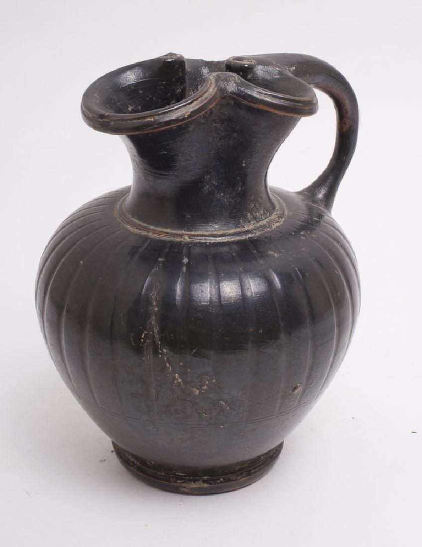 Ancient Apulian Pottery Jug Circa 4th Century BC.: Ancient Apulian Pottery Jug Circa 4th Century BC. Size 4 3/4 inches high. Fine Black-ware footed Ribbed trefoil jug. Condition:Perfect. Provenance: from the estate of Robert Thompson of Philadelphia,