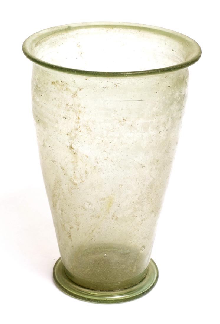 Ancient Roman Footed Glass Cup c.2nd century AD.: Ancient Roman Footed Glass Cup c.2nd century AD. Size 4 1/4 inches high. Large Ancient Ancient Green glass footed Beaker (wine cup). Condition: perfect. Provenance: from the estate of Robert Thompson