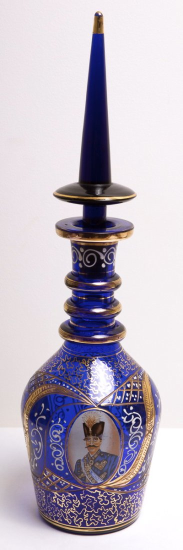Persian Blue Glass Decanter with Shah portrait: Persian Blue Glass Decanter with Shah portrait. Size 19 3/8 inches high. Beautiful cobalt blue glass decanter with stopper decorated in gold and enamel with Portrait of Shah on both sides. Minor wear