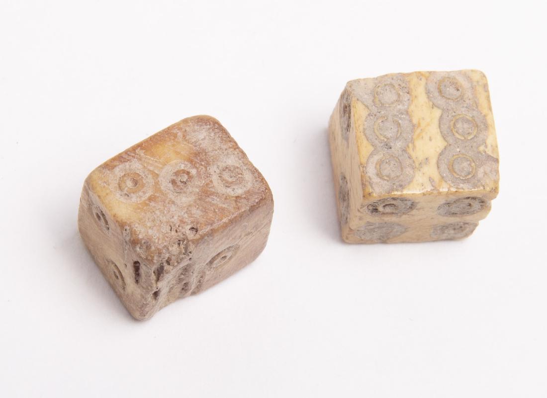 A Pair of Ancient Roman Carved Bone Dice, Circa 2nd: A Pair of Ancient Roman Carved Bone Dice, Circa 2nd-3rd century AD. Size 12 mm. A Matching pair of Roman Bone Dice, Rough fashioned cut gaming pieces, each face of the die with incised numbers. Aged d