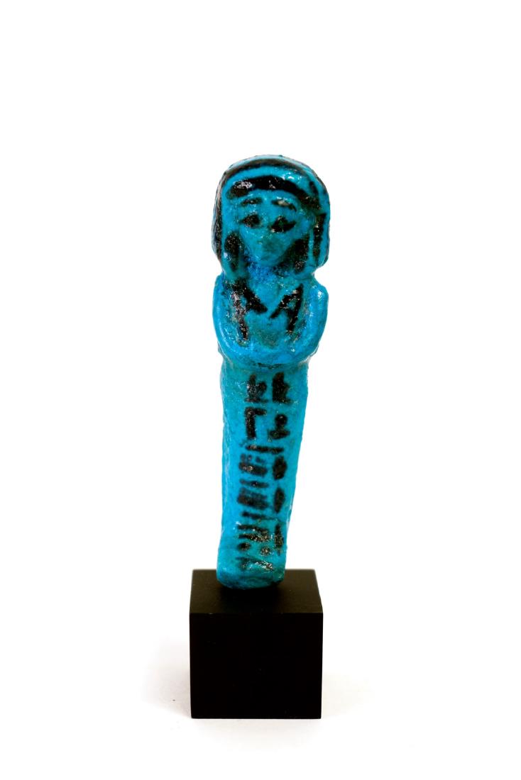 Egyptian Turquoise Glaze Ushabti for Amenemope: Egyptian Turquoise Glaze Ushabti for Amenemope From Tel Assassif, 22nd Dynasty ca. 943-716 BC.Molded brilliant blue glazed faience ushabti with sweet face and wearing bag wig.He stands in a mummiform