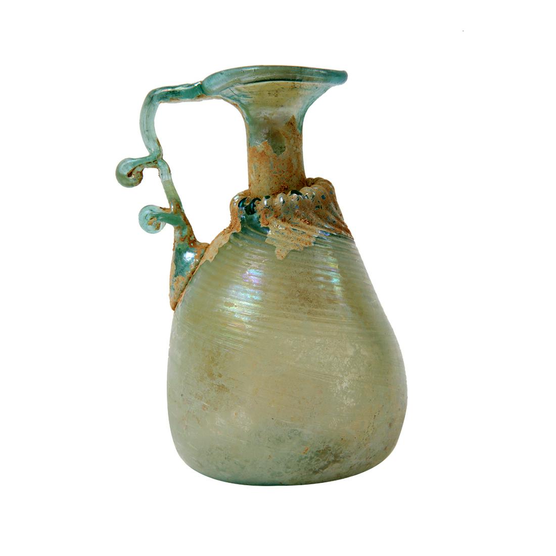 Ancient Holy Land Roman Glass Jug c.1st-2nd century AD.: Ancient Holy Land Roman Glass Jug c.1st-2nd century AD. Size 4 1/4 inches high. Beautiful and rare form ancient Roman Glass jug with unusual handle, amazing silver iridescent patina. Condition Intact.
