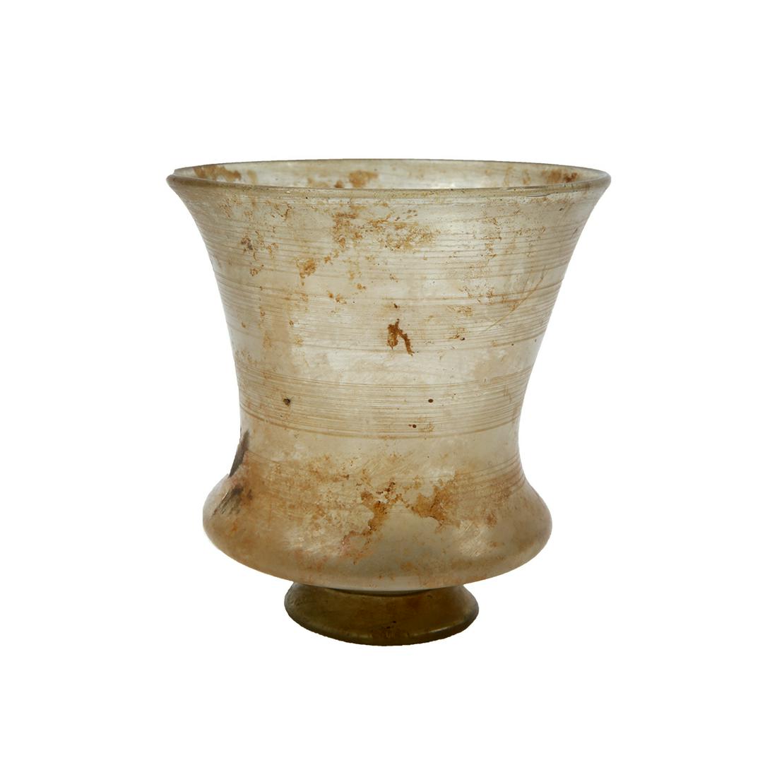 Ancient Holy Land Roman Glass Beaker c.1st-2nd century: Ancient Holy Land Roman Glass Beaker c.1st-2nd century AD. Size 5 1/8 inches high x 4 7/8 inches diameter. Rare form large ancient Roman green glass footed Beaker with wheel cut lines with twin handle