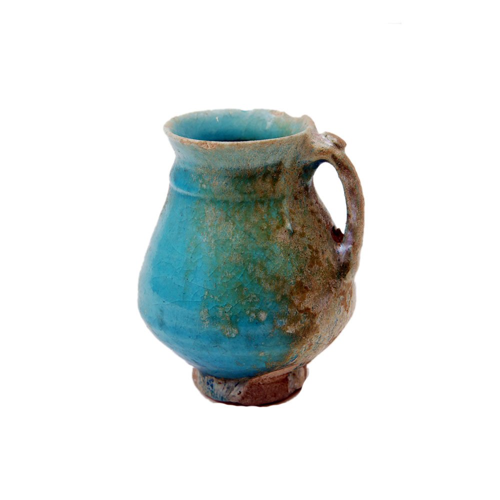 Ancient Islamic Ceramic jug c.13th century AD.: Ancient Islamic Ceramic jug c.13th century AD. Size 3 3/4 inches high. A turquoise color glazed footed cermaic jug with nice patina. Provenance: Ex David Saidian Estate New York city. to present owner