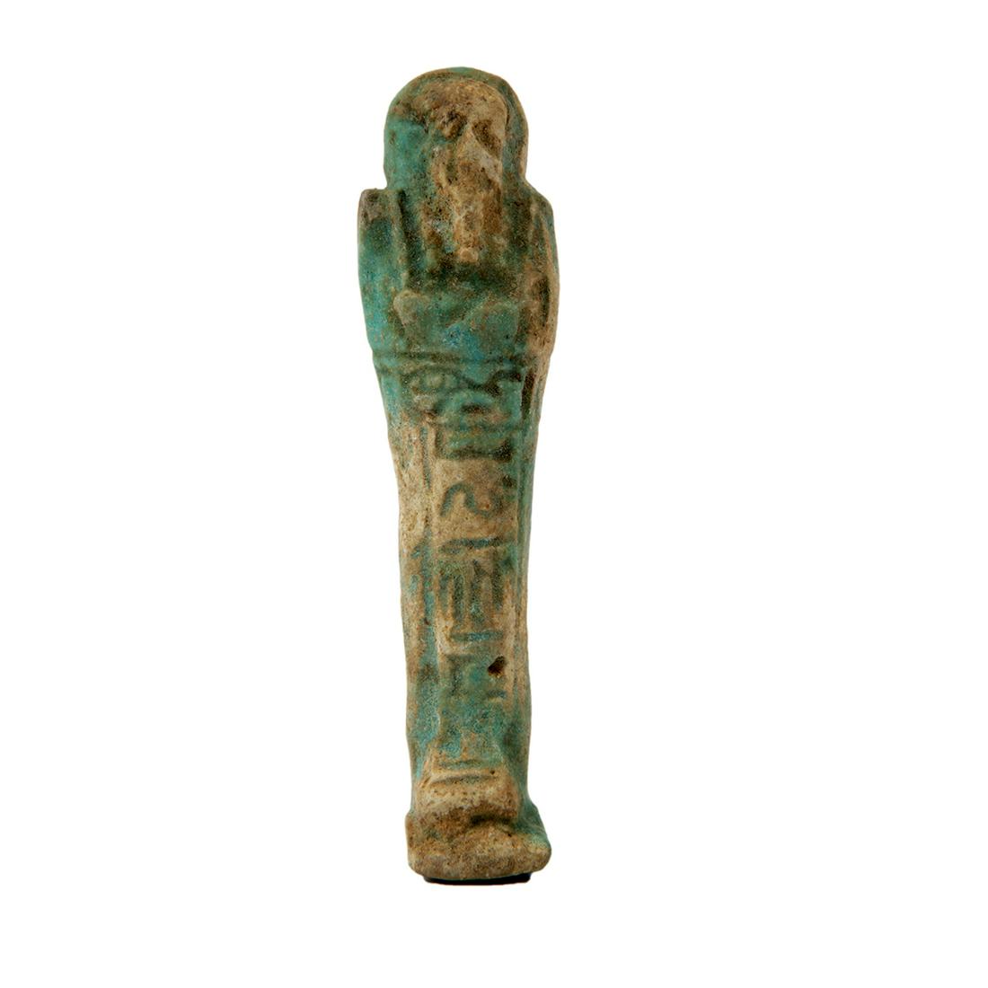 Ancient Egyptian Faience Ushabti Figure c.700 BC.: Ancient Egyptian Faience Ushabti Figure c.700 BC. Size 4 inches high. A blue-green glazed faience ushabti figure, wearing the royal wig and beard, holding implements and seed sack on back with a line 