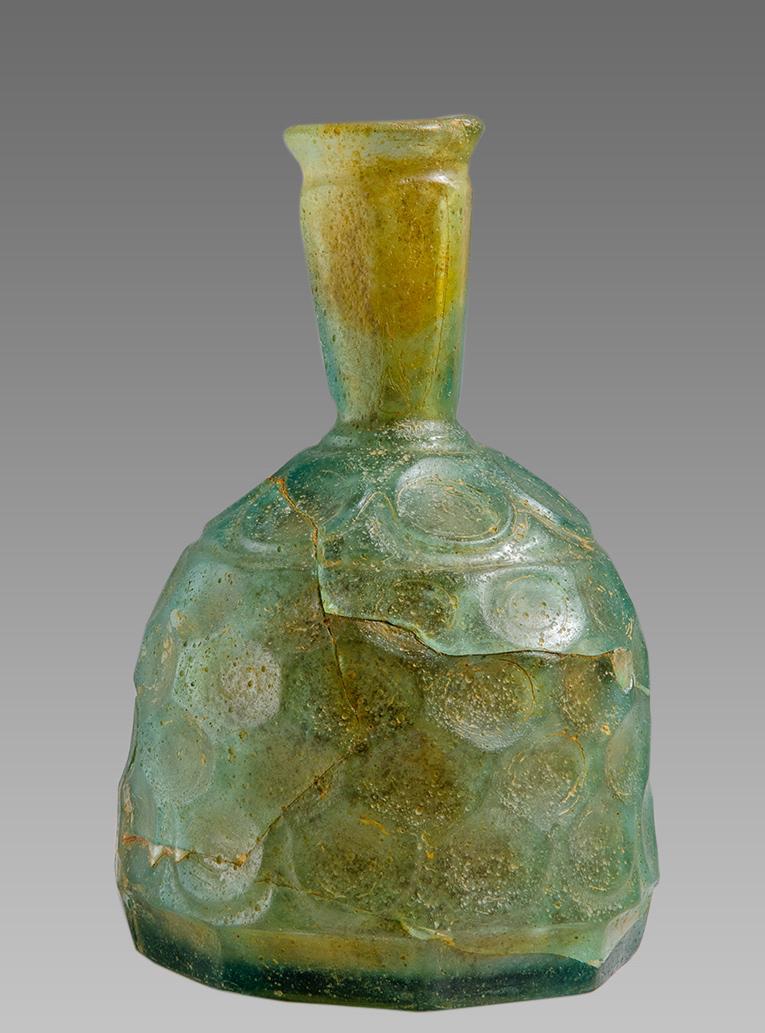 Ancient Sasanian Cut Glass Bottle c.6th century AD.: Ancient Sasanian Cut Glass Bottle c.6th century AD. Size 5 inches high. Rare Sasanian cut green glass bottle with ornate cut design on the outerside. Provenance: Ex Private New York City Collection ac