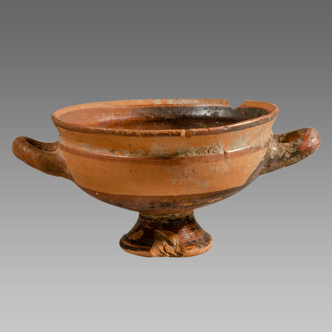 Ancient South Italian pottery Kylix Circa 350 B.C.: Ancient South Italian pottery Kylix Circa 350 B.C. Size 2 3/8 inches high. 6 3/4 inches across handle span. A pottery Kylix with twin handles. Provenance: Ex Private New York City collection acquired 