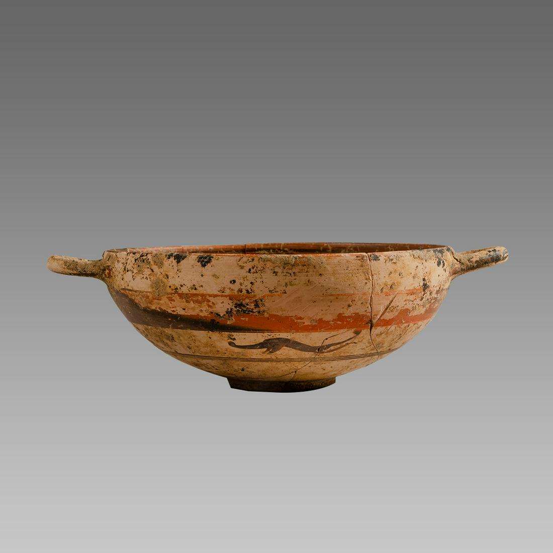 Ancient South Italian pottery Kylix Circa 350 B.C.: Ancient South Italian pottery Kylix Circa 350 B.C. Size 2 inches high. 6 7/8 inches across handle span. A pottery Kylix with twin handles decorated with running animal at back. Provenance: Ex Private 