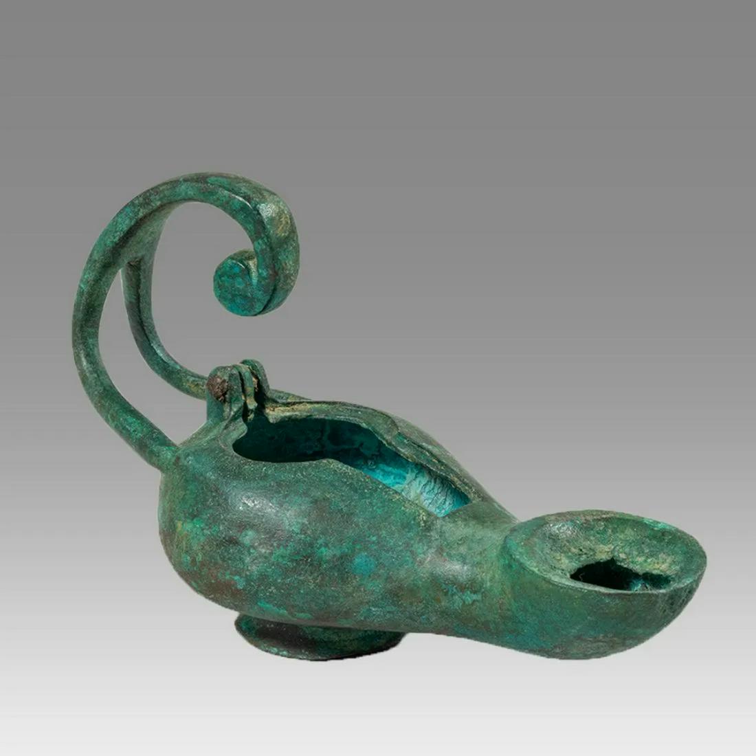 Ancient Byzantine Bronze Oil Lamp Ca. 6th century AD.: Ancient Byzantine Bronze Oil Lamp Ca. 6th century AD. Size 5 5/8 inches length. Cast bronze footed oil lamp with elaborate handle. choice patina. Provenance: NYC collection, acquired from Philips Lond
