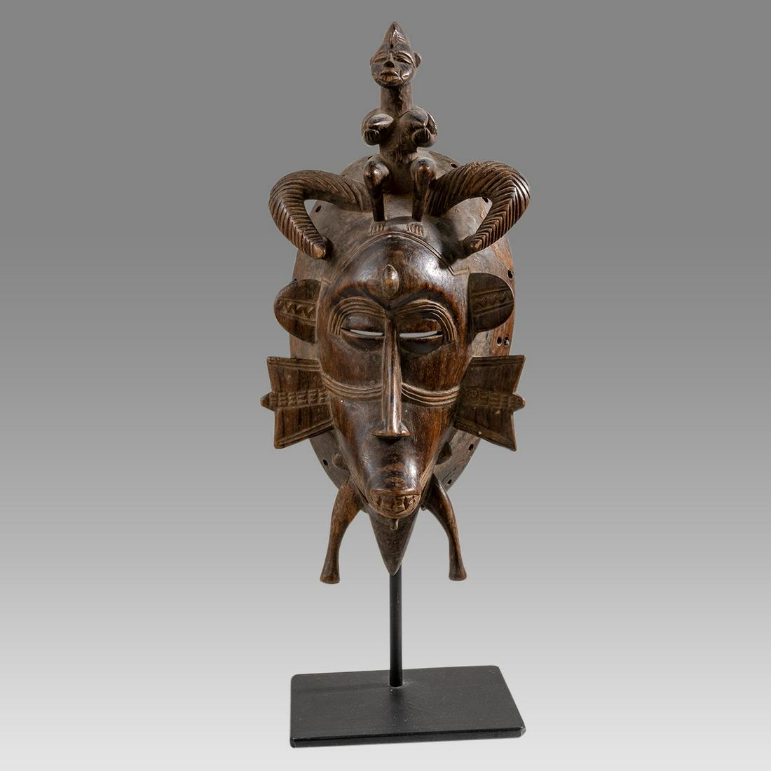 Africa, Mali, Kpelie, Senufo complex face mask, personage on top.: Africa, Mali, Kpelie, Senufo complex face mask, personage on top. Size 12 inches high. + mount. 5 inches wide. Fine carved wood complex face mask, personage on top. Custom mounted. Provenance: Private