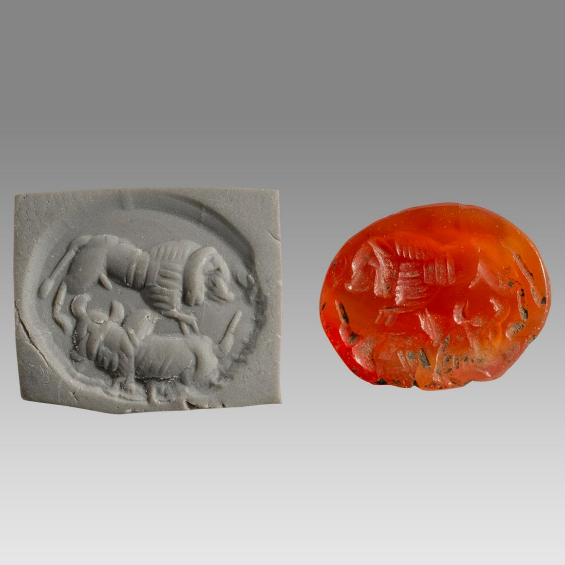 Ancient Roman Carnelian Intaglio with Animals c.2nd-4th century AD.: Ancient Roman Carnelian Intaglio with Animals c.2nd-4th century AD. Size 16 - 13 mm. Fine orange carnelian depicts a lion and a zebu bull. Provenance: Private NYC collection, acquired 1980s from Henry