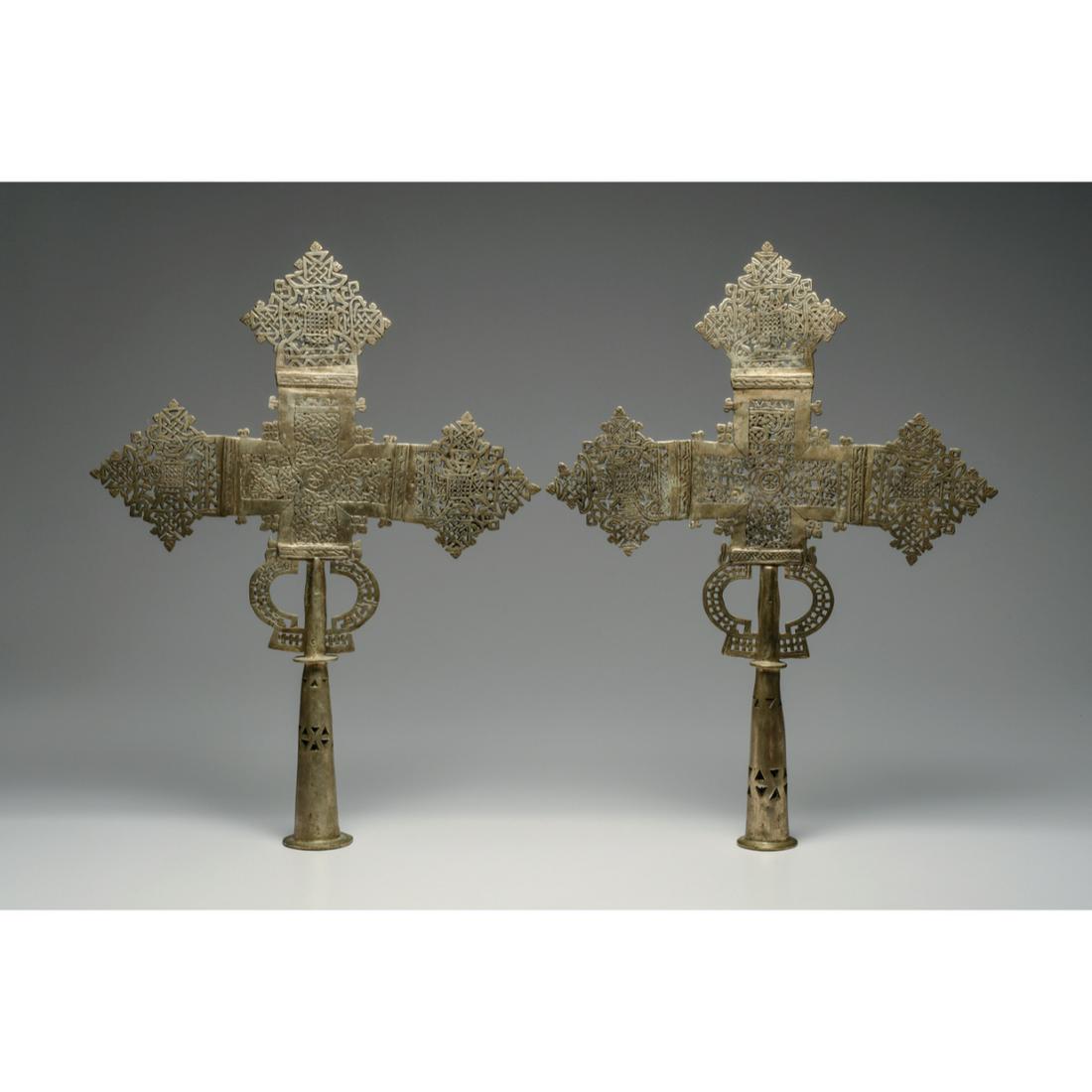 Pair of Ethiopian Coptic Processional Crosses Ca. 20th century.: Pair of Ethiopian Coptic Processional Crosses Ca. 20th century.. Size 21 1/2 inches high, 16 inches wide. Matching pair of cast and silvered brass crosses, each decorated on both sides, having an over