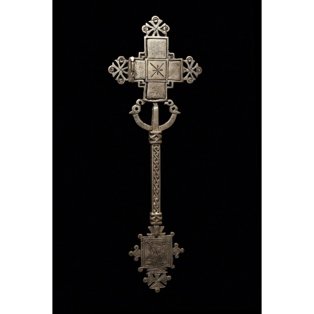 Ethiopian Coptic Processional Cross Ca. 20th century.: Ethiopian Coptic Processional Cross Ca. 20th century. Size 14 inches high, 4 6/8 inches wide. A cast Low grade silver processional cross having openwirk and guilloche designs. Small relic door opens t