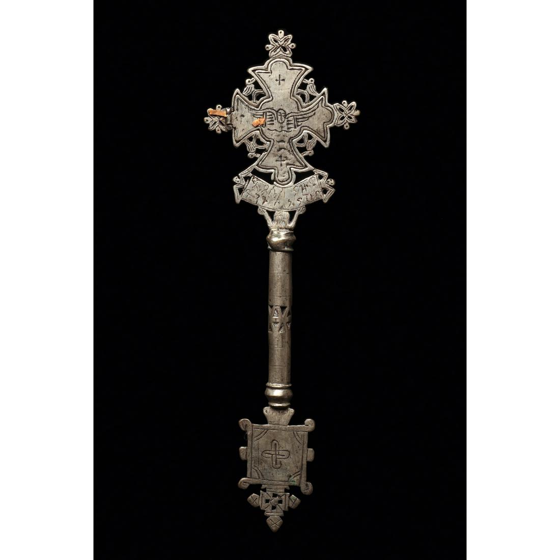 Ethiopian Coptic Processional Cross Ca. 20th century.: Ethiopian Coptic Processional Cross Ca. 20th century. Size 12 1/2 inches high, 4 inches wide. A cast Low grade silver processional cross having openwirk and geometric designs. Small relic door opens t