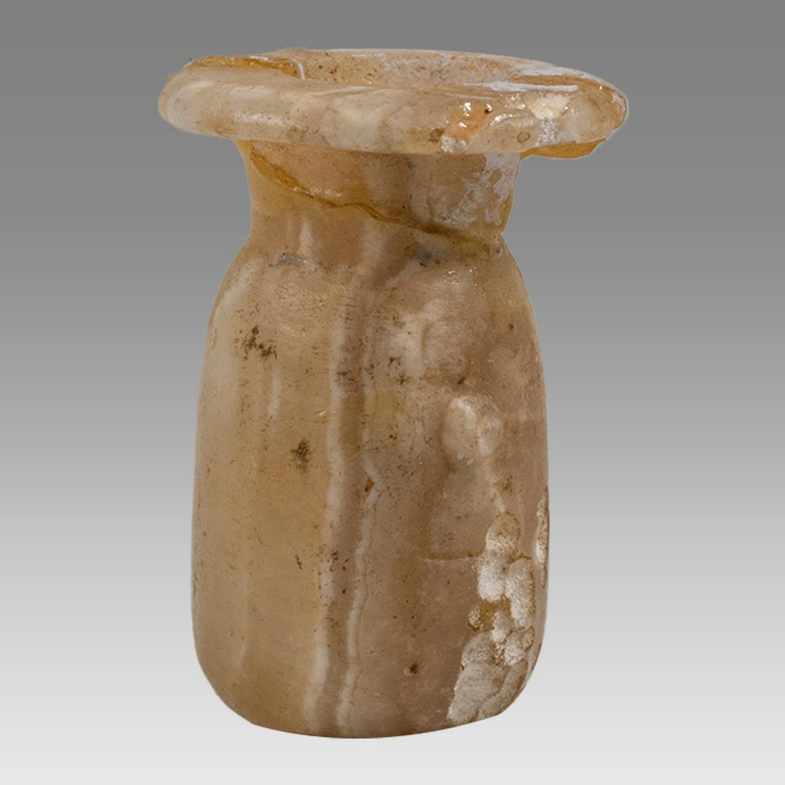 An Egyptian alabaster cosmetic jar, Late Period, c. 664 - 30 BC: An Egyptian alabaster cosmetic jar, Late Period, c. 664 - 30 BC, of translucent material with attractive vertical banding. H: 1 1/3 in (3.5cm). Repair and a few losses at neck and rim. Ex Collection o