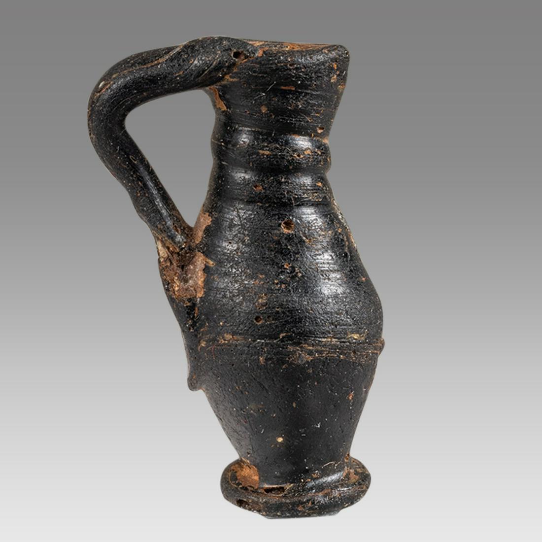 Ancient Roman Glass Unguent Bottle, ca. 100 AD to 200 AD.: Ancient Roman Glass Unguent Bottle, ca. 100 AD to 200 AD. A small glass blown Cobalt/Black bottle used to hold perfume oil. 3.2 cm H, 1.2 cm W, 1.0 cm D. Private New York City Collection, purchased fr