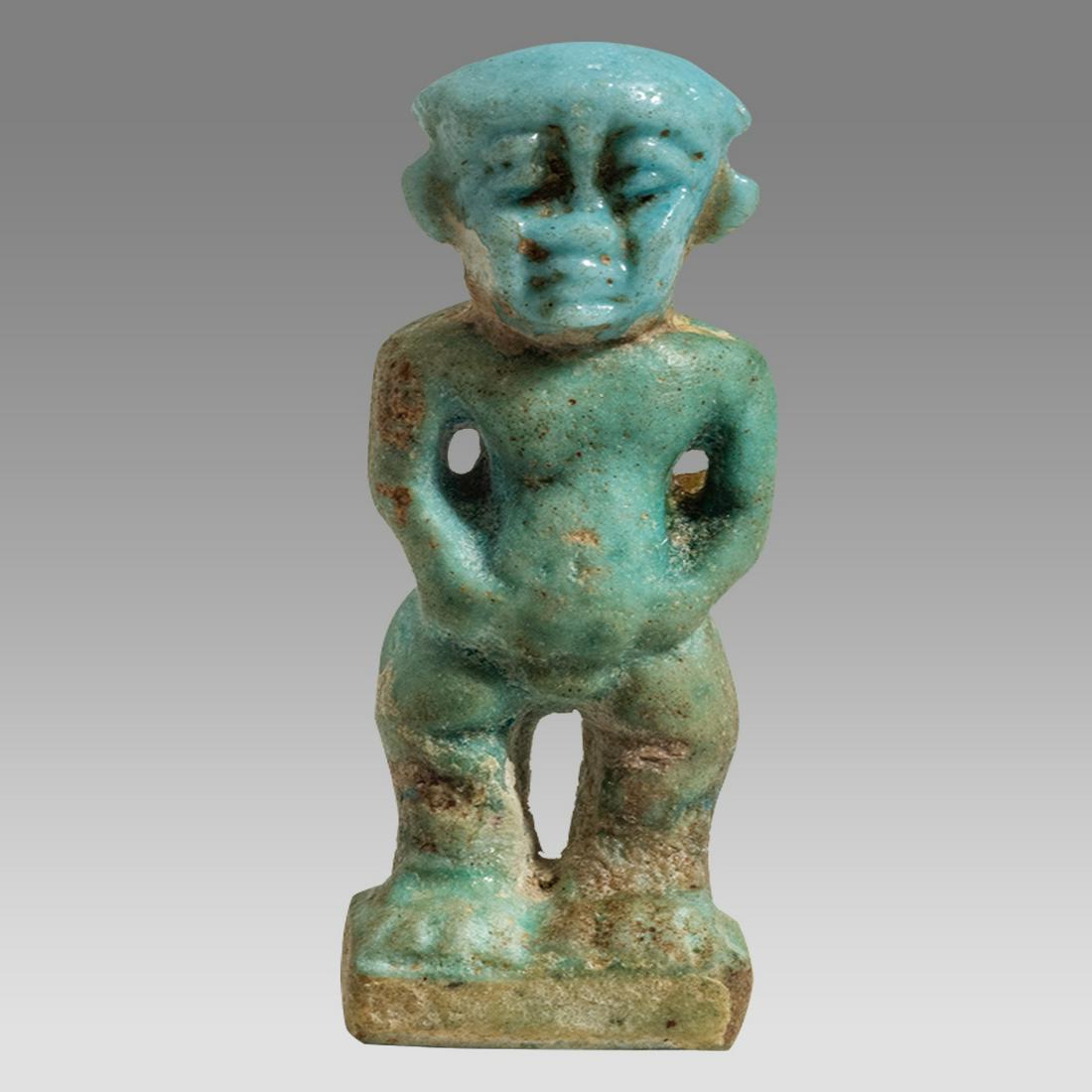 Ancient Egyptian Faience Dwarf Pataikos Amulet c.664-525 BC.: Ancient Egyptian Faience Dwarf Pataikos Amulet c.664-525 BC. Size 1 1/2 inches high. Fine blue faience Pataikos amulet depicted as facing squating dwarf, in the round; loop for suspension to rear. Pro