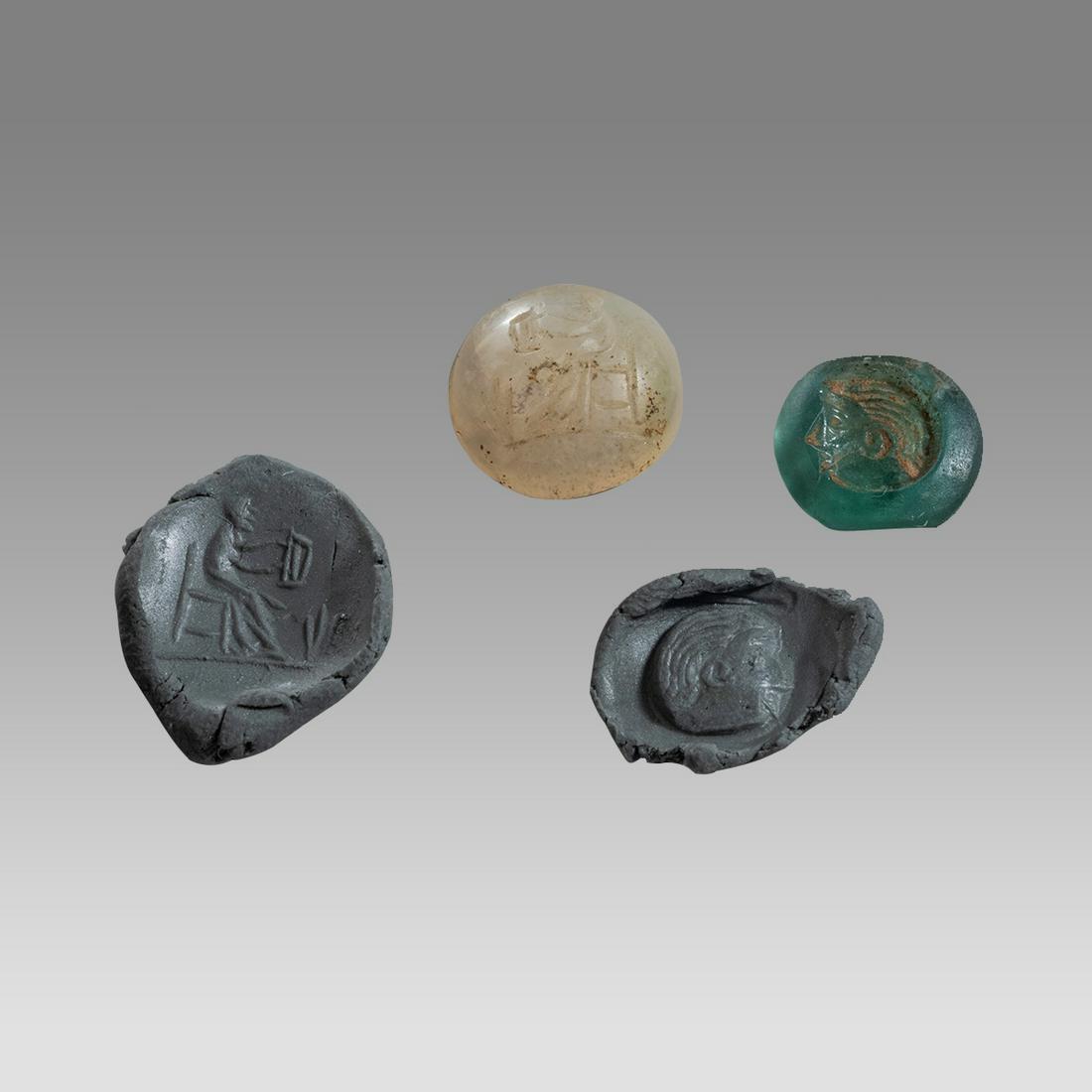 Lot of 2 Ancient Roman Agate, Glass Intaglios c.2nd century AD.: Lot of 2 Ancient Roman Agate, Glass Intaglios c.2nd century AD. Size 13 - 14 mm. Fine carved Agate Intaglio with seated musician holding lyre, a green glass intaglio with head of a youth facing right.