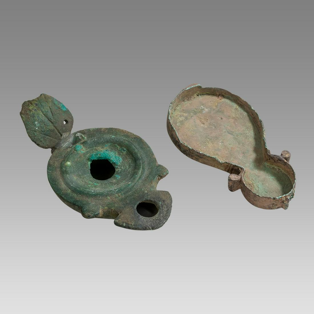 Lot of 2 Ancient Roman Bronze Oil Lamps c.1st-4th century AD.: Lot of 2 Ancient Roman Bronze Oil Lamps c.1st-4th century AD. Size 5 1/2- 5 3/4 inches length x 0 3/4 - 2 1/4 inches high. a lot of 2 Ancient Roman Empire Bronze oil lamps. large one handle repaired w