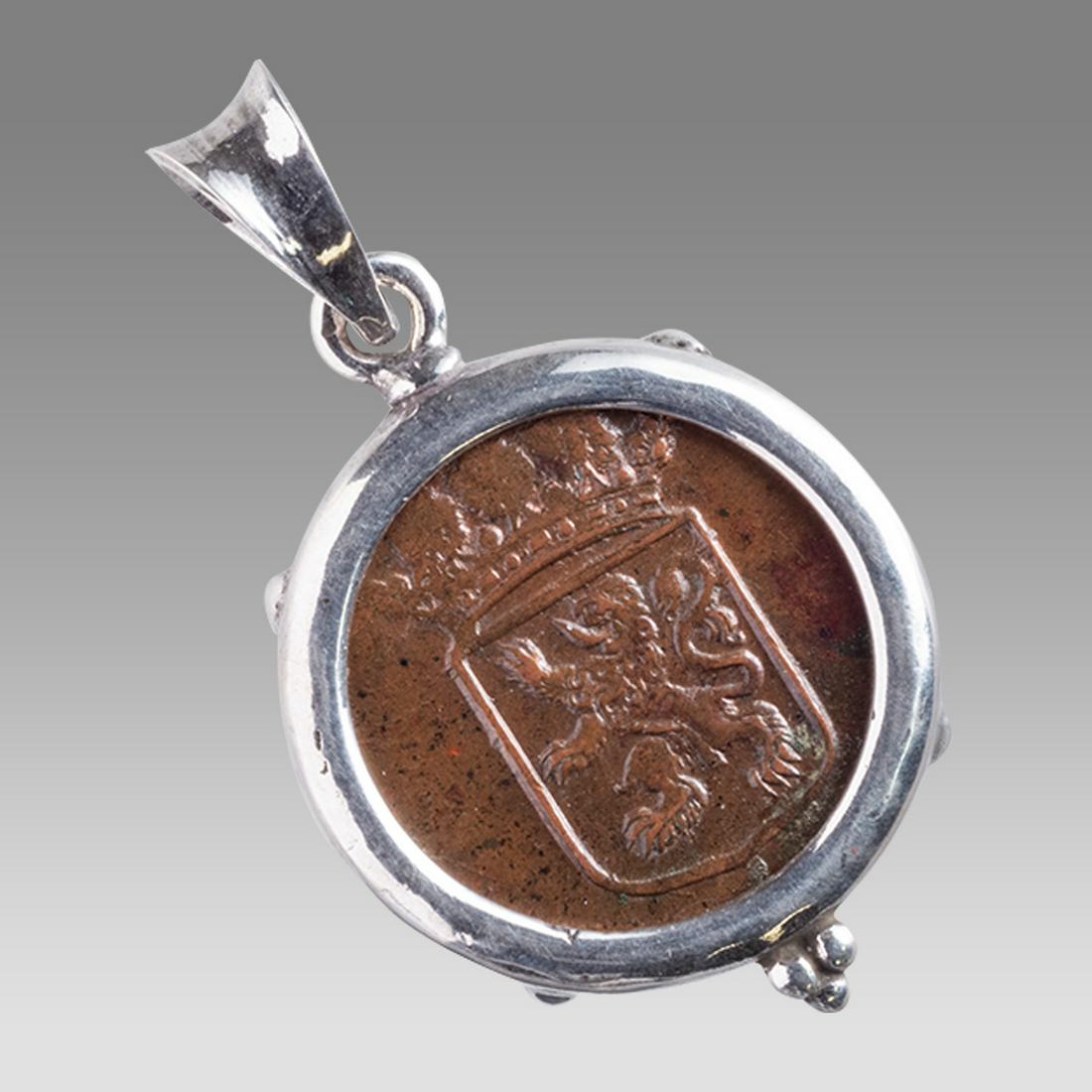 VOC Bronze Coin 1730 Set in Silver Pendant.: VOC Bronze Coin 1730 Set in Silver Pendant. Size 24 mm diameter. Antique bronze coin VOC Dated 1730, Set in Modern Silver pendant. The coin is antique, the setting is modern. wearable
