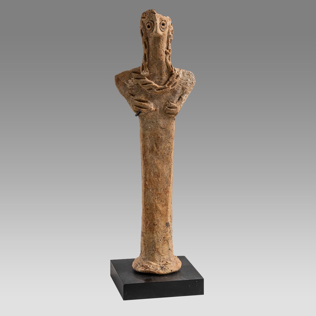 ANCIENT SYRO-HITTITE Ashtar Terracotta IDOL c.2nd millennium B.C.: ANCIENT SYRO-HITTITE Ashtar Terracotta IDOL c.2nd millennium B.C. Size 7 1/4 inches high + stand. Fine molded female Ashtar Idol with bird-like face wearing headdress, both hands resting on her breast