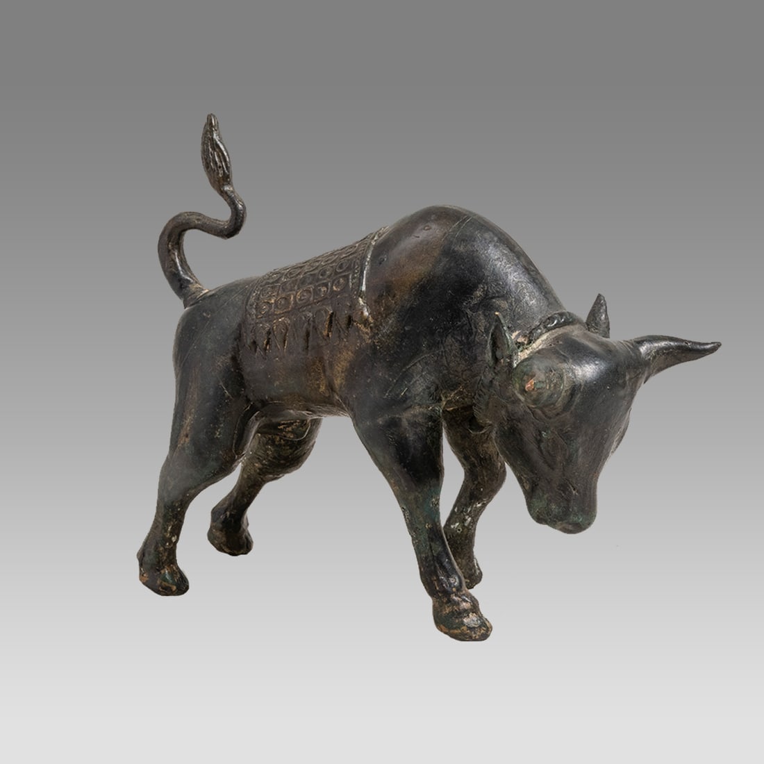 Antique Chinese Bronze Bull.: Antique Chinese Bronze Bull. Size 6 1/4 inches length, 5 1/2 inches high. Cast hollow bronze figure of a Bull wearing saddle bag with ornate design. Lovely patina. Ex NY Estate.