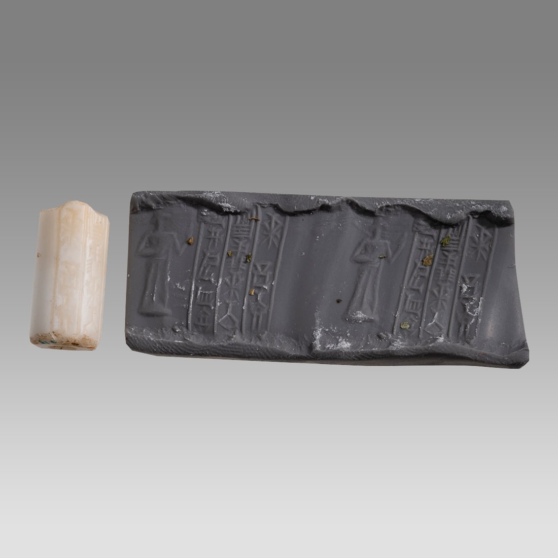 Babylonian Style Marble Cylinder Seal With Inscriptions.: Babylonian Style Marble Cylinder Seal With Inscriptions. Size 22 x 11 mm. Marble cylinder seal engraved with figure and three lines of Sumerian inscriptions. Not ancient. Ex Fortuna Gallery NYC.