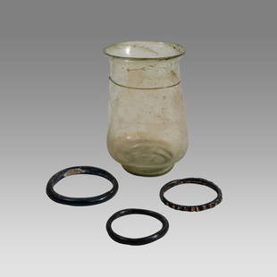 Lot of Ancient Roman Glass Cylindrical Cup & 3 Ancient Roman Glass Bracelets (ca. 1st-3rd century: Lot of Ancient Roman Glass Cylindrical Cup & 3 Ancient Roman Glass Bracelets (ca. 1st-3rd century CE). Size of cup 4 1/4 inches high. Bracalet Size 2 ¼ -1 5/8 inches diameter.. The delicate gre