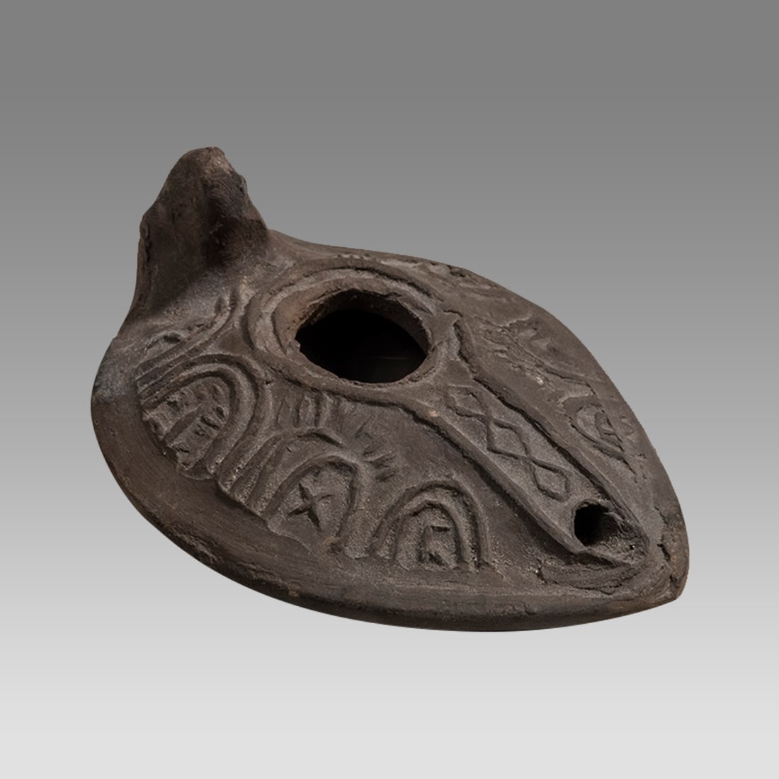 Ancient Roman Terracotta Oil lamp c.2nd century AD.: Ancient Roman Terracotta Oil lamp c.2nd century AD. Size 3 3/4 inches length. A dark clay oil lamp with decoration. Provenance: Private Historian collection Richard and Eleanor Brilliant NYC acquired