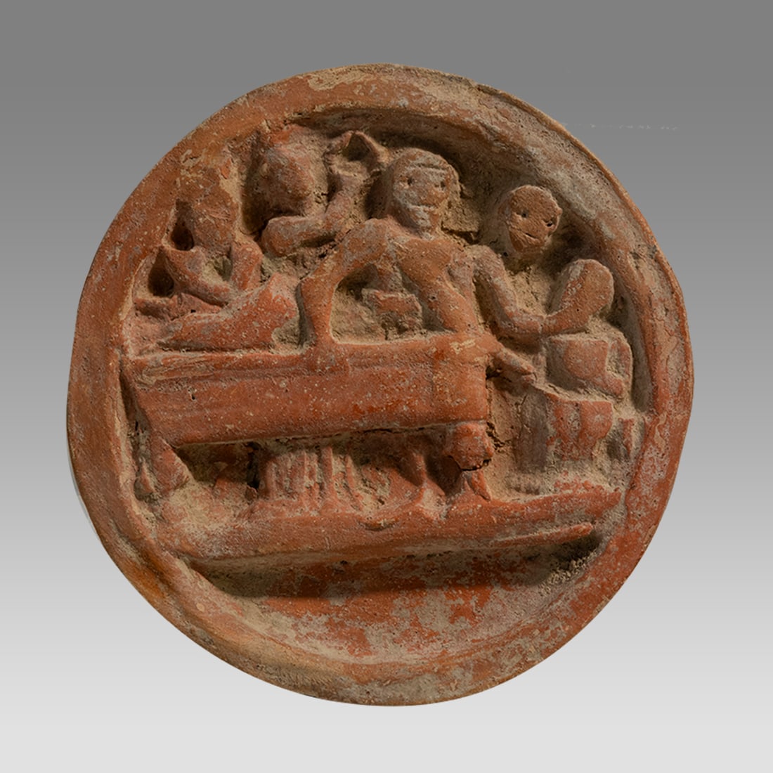 Ancient Gandhara Pottery Cosmetic Palette c.2nd century AD.: Ancient Gandhara Pottery Cosmetic Palette c.2nd century AD. Size 4 1/2 inches diameter. Rare red pottery palette with relief scene of bearded man reclining on bench with four female figures. Provenanc