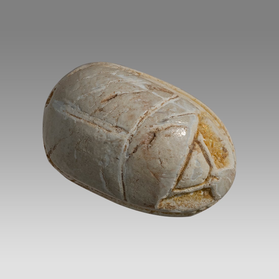 Ancient Egyptian Steatite Scarab New Kingdom c.1550-1070 BC.: Ancient Egyptian Steatite Scarab New Kingdom c.1550-1070 BC. Size 14 x 10 mm. A Steatite Scarab with stylized beetle back and bezel base engraved with kneeling figure holding palm. Provenance: Private
