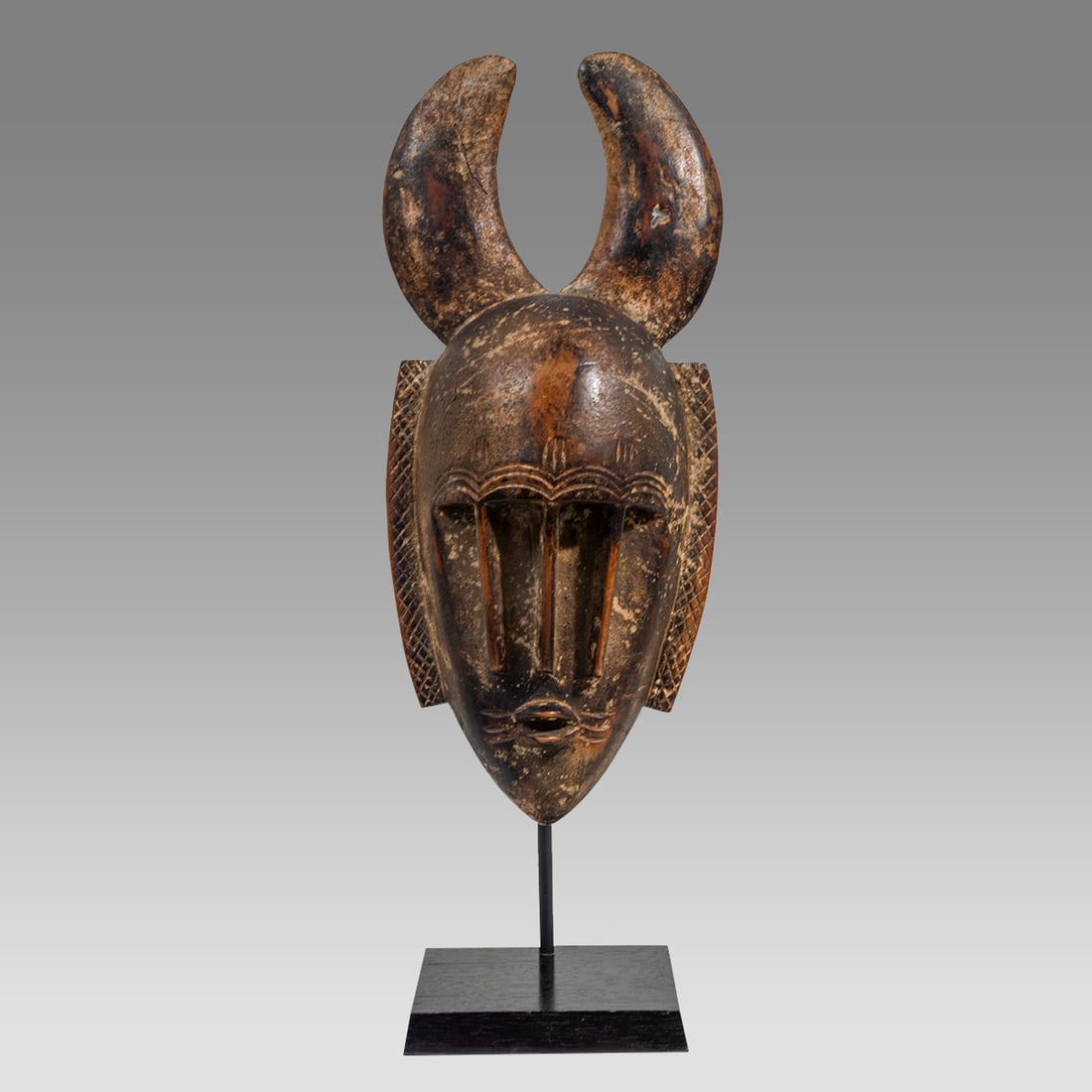 African, Cote d'Ivoire Jimini Or Ligbe Face Mask.: African, Cote d'Ivoire Jimini Or Ligbe Face Mask. Size 13 3/4 inches high + stand, 6 1/4 inches wide. Attractive and unusual carved wood mask with horns, the face with stylized three nose, small mouth