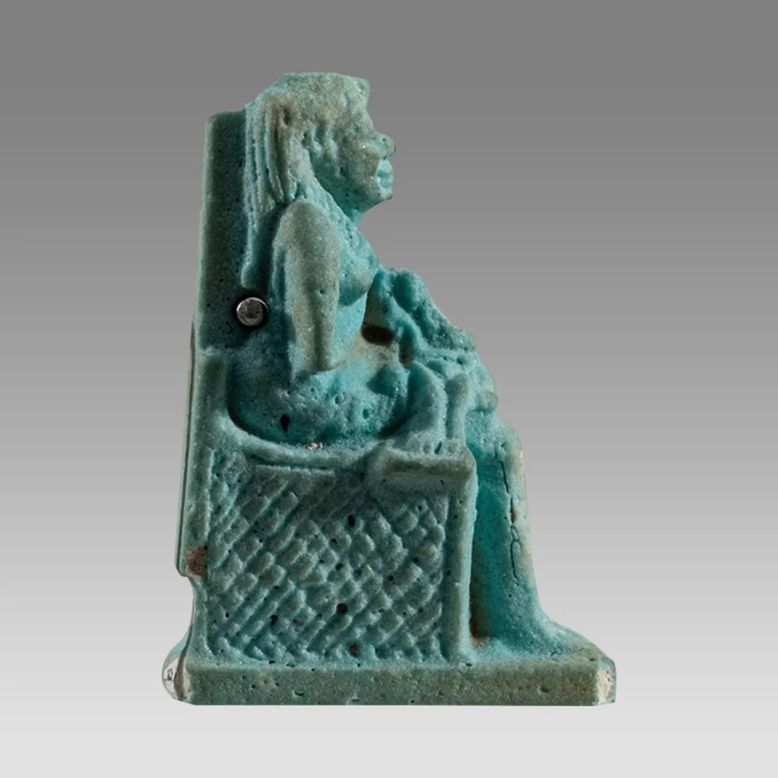 Ancient Egyptian Isis w/Horus-Child Faience Amulet (ca. 700-30 BCE).: Ancient Egyptian Isis w/Horus-Child Faience Amulet (ca. 700-30 BCE). Measures 1-9/16”H. Light blue glazed Late Period faience pottery amulet depicting the enthroned Isis suckling the baby Horus.