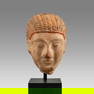 Archaic Greek stone head of a Kouros, c. 6th Century BC.