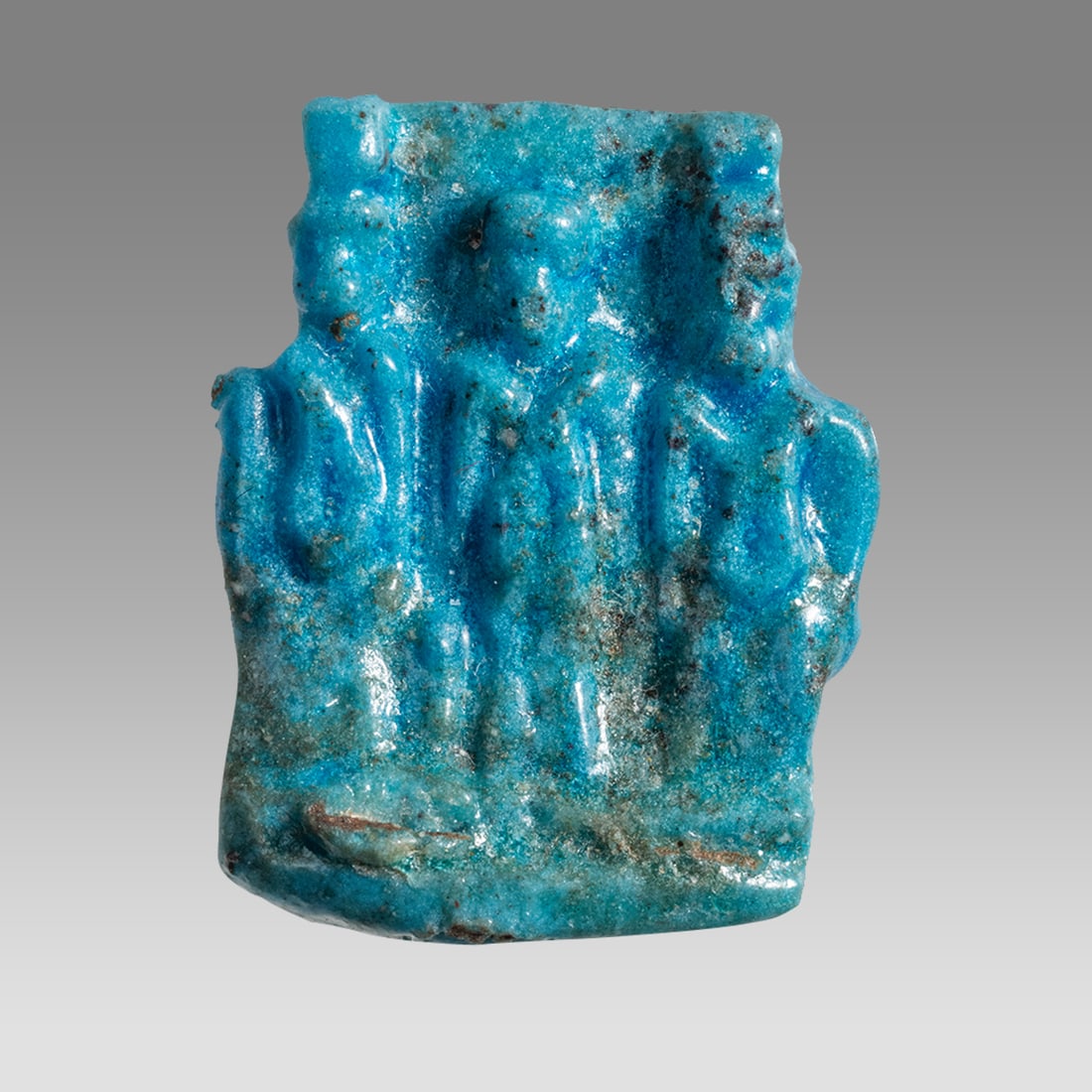 Ancient Egyptian Faience Triad Plaque Amulet c.663-525 BC.: Ancient Egyptian Faience Triad Plaque Amulet c.663-525 BC. Size 26 x 20 mm. Fine blue faience plaque featuring three standing figures of Isis, Horus-the-child and Nebhat. Provenance: Ex Secret Eyes Ga