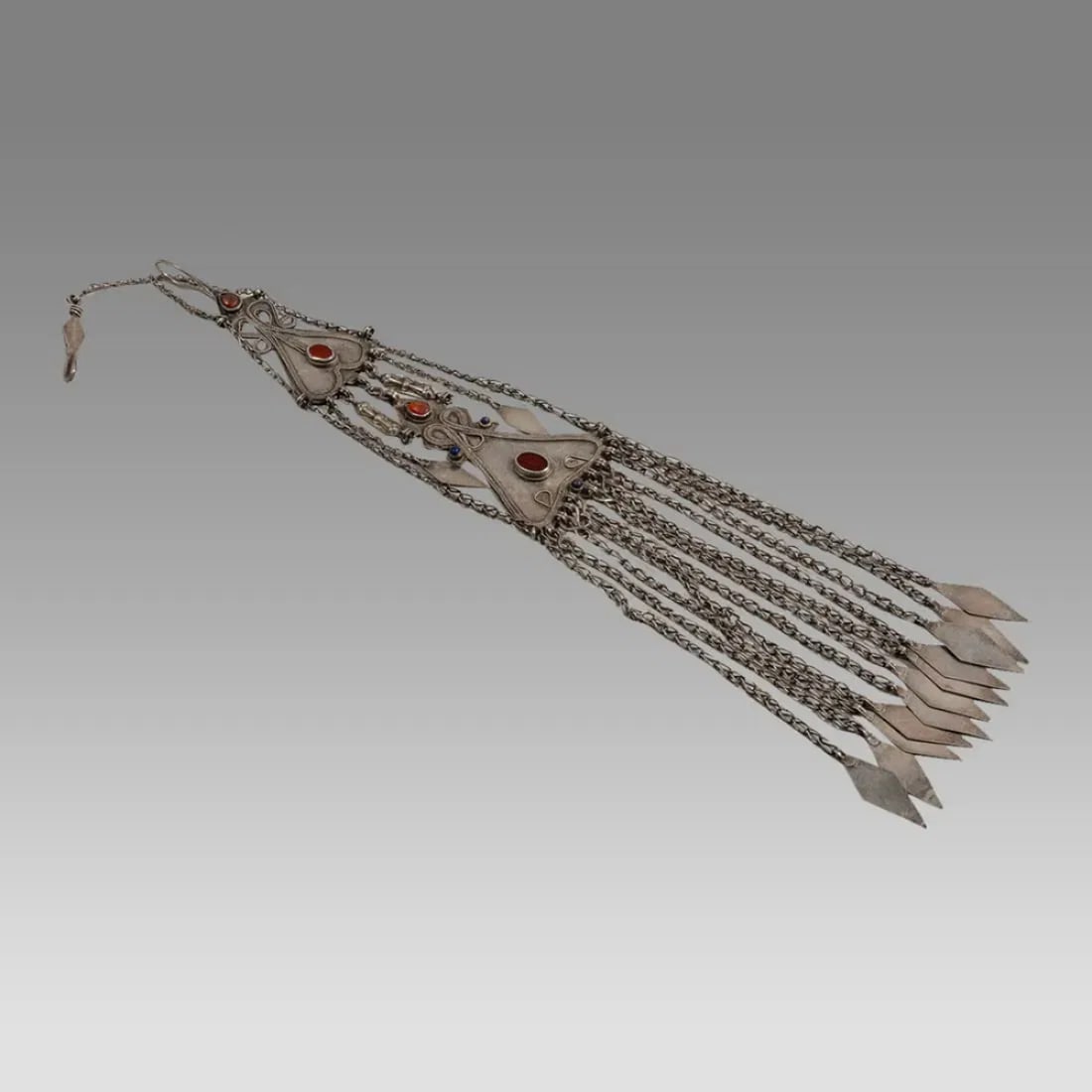 Single large Ersari Turkoman temporal ornament with carnelian and lapis insets.: Single large Ersari Turkoman temporal ornament with carnelian and lapis insets. Size 22 1/2 inches length. Weight 217 grams. Provenance: Private HI USA collection acquired from the collection Ella Fre
