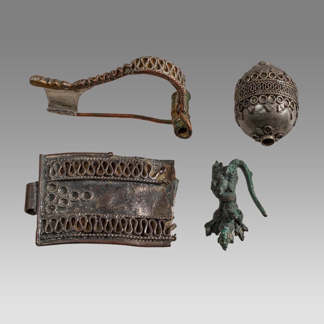 Lot of 3 Antique Islamic Ornaments c.19th century.: Lot of 3 Antique Islamic Ornaments c.19th century. Size 1 1/4 - 2 inches length. Lot of 3 silver strap end, hollow bead and silver fibula, together with a cast bronze Thai single earring. Provenance: