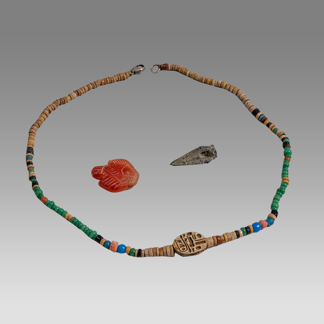 Scythian Arrowhead, Scarab Necklace and Carnelian Fish (3): Scythian Arrowhead, Scarab Necklace and Carnelian Fish (3) Size 1 - 17 3/4 inches length. Bronze point of triangular/pyrimidal form having hollow socket. Some encrustation. Scarab necklace. Some ancie