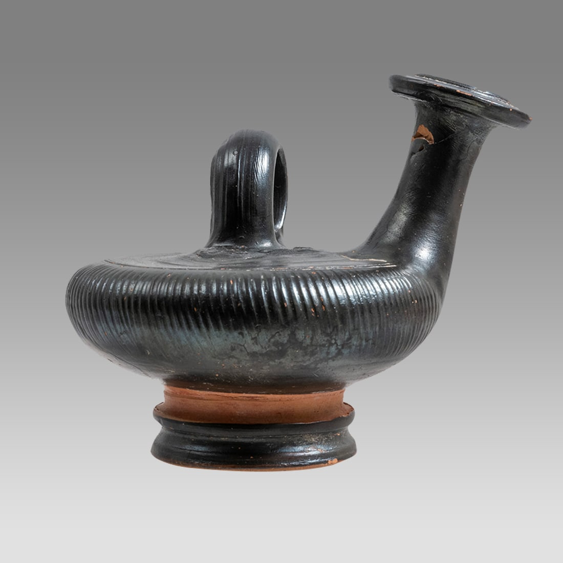 Ancient Apulian Blackware Guttus c.350 BC.: Ancient Apulian Blackware Guttus c.350 BC. Size 3 1/2 inches diameter, 3 5/8 inches high. Oil filler with rounded body, tall spout, loop handle. At the center, a medallion of head of an African with b
