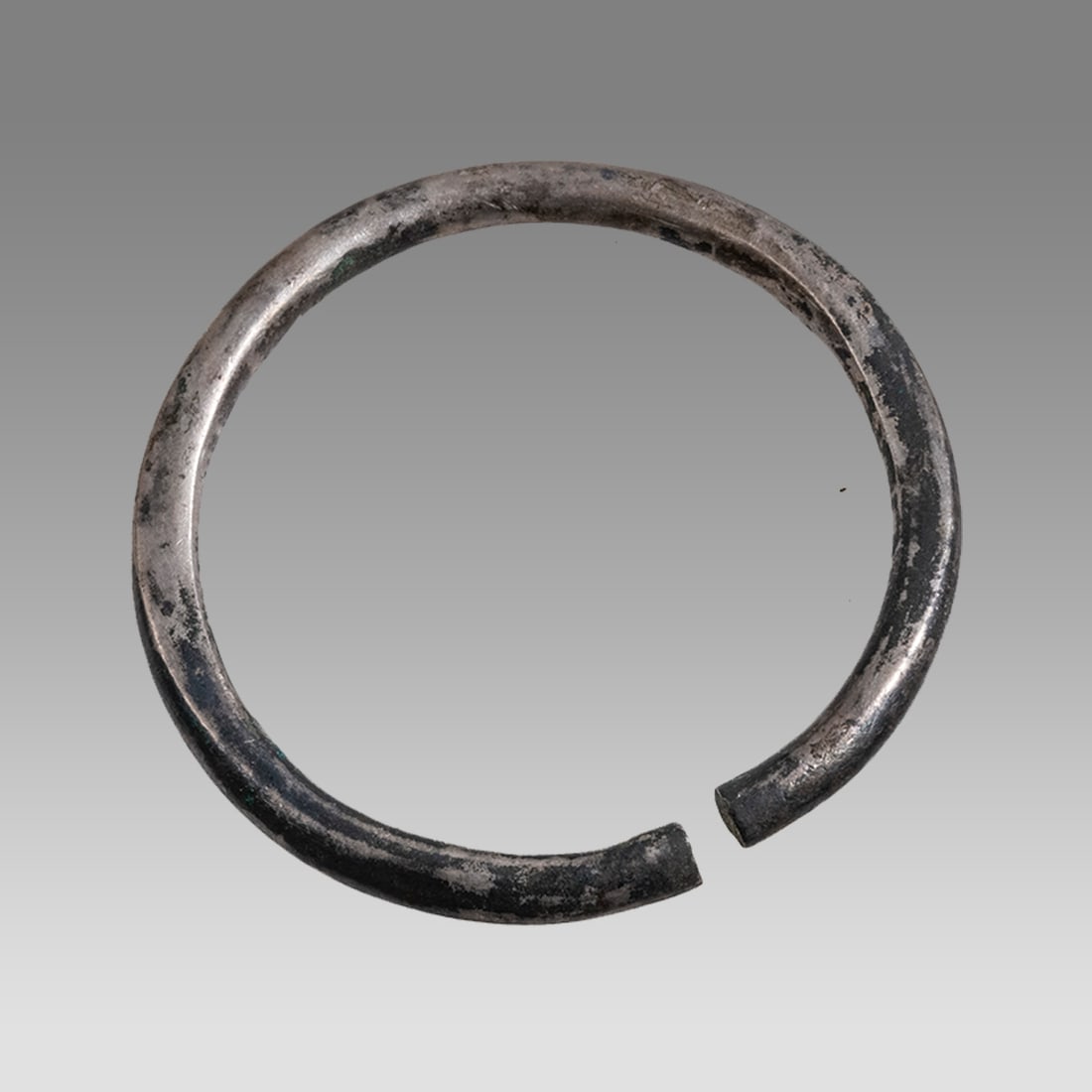 Ancient Luristan Silver Bracalet c.1000 BC.: Ancient Luristan Silver Bracalet c.1000 BC. Size 2 1/2 inches diameter. A small silver bracalet decorated with nice surface patina. Provenance: From a NYC collection acquired in the 1960s
