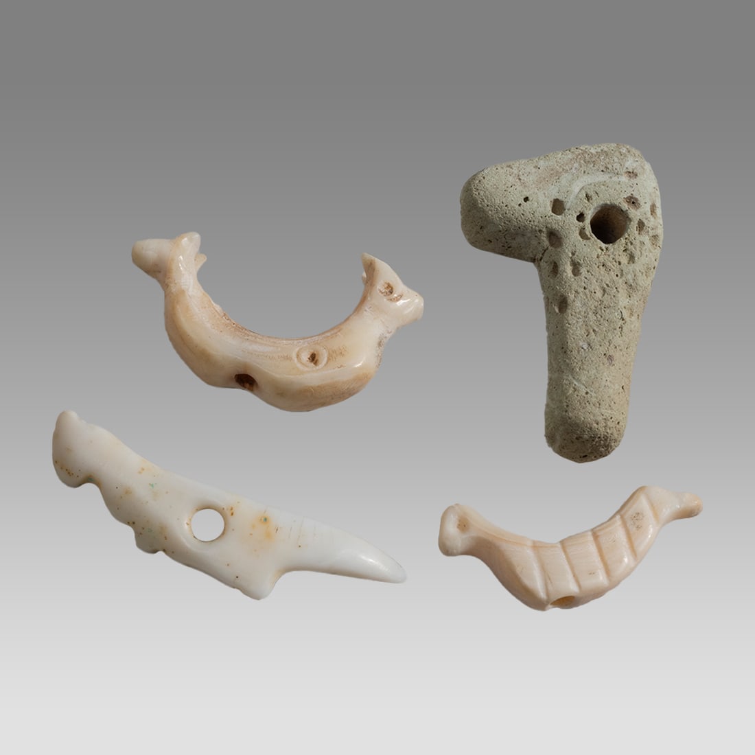 Lot of 4 Ancient Mesopotamian Shell Animal Amulets c.5000-3000 BC.: Lot of 4 Ancient Mesopotamian Shell Animal Amulets c.5000-3000 BC. Size 21-27 mm. Lot of 3 Sumerian shell animal amulets with Suspebsion hole. Together with a Clay head of animal. Provenance: Private