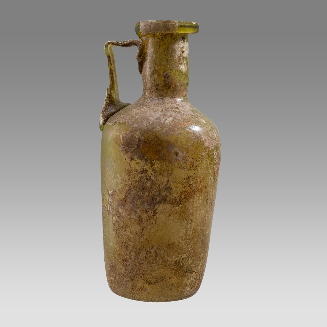 Ancient Roman Yellow-Green Glass Bottle with Handle, 2nd-4th C CE,: Ancient Roman Yellow-Green Glass Bottle with Handle, 2nd-4th C CE, Size 5 5/8 inches high.?Free blown medium yellow-green glass bottle having an applied ribbon glass handle and tooled folded rim lip.