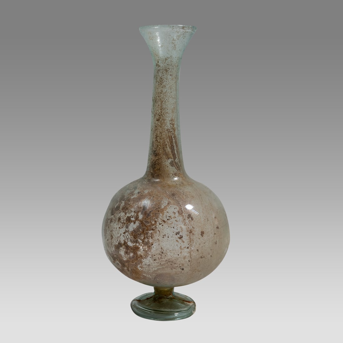 Ancient Roman Footed Glass Bottle c.2nd-3rd century AD.: Ancient Roman Footed Glass Bottle c.2nd-3rd century AD. Size 6 3/4 inches high. Ancient Roman footed Glass bottle with bulbous body and tall neck with flared rim. Rare form. Provenance: Ex NYC Collect