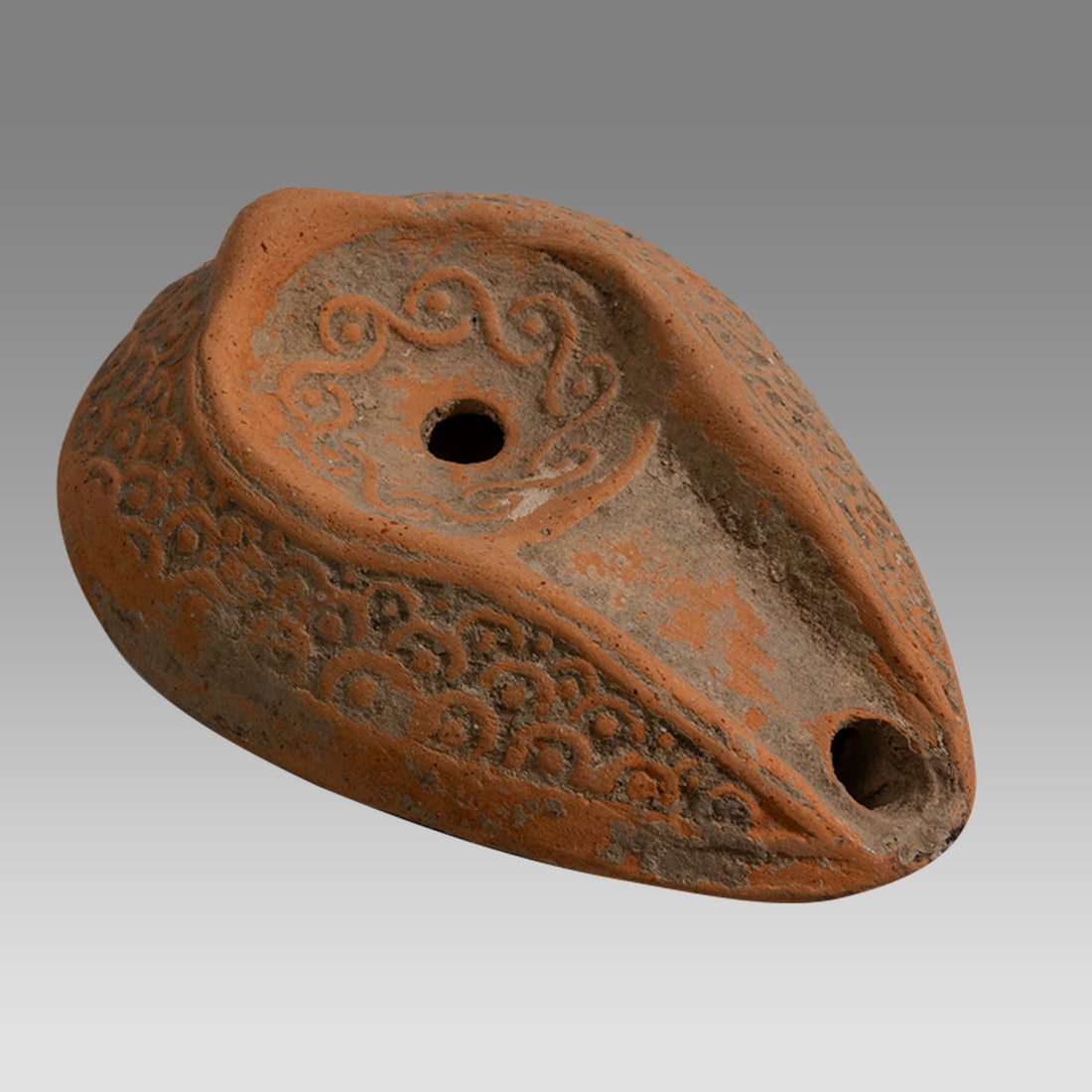 Ancient Holyland Byzantine Terracotta Oil Lamp c.5th century AD.: Ancient Holyland Byzantine Terracotta Oil Lamp c.5th century AD. Size 3 7/8 inches length. Fine red Terracotta oil lamp decorated with ornate design. Provenance: From a Private NYC Collection acquired