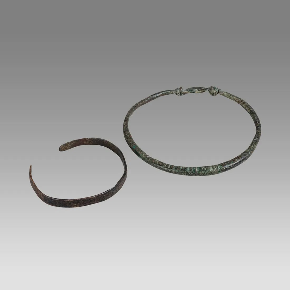lot of 2 Ancient Roman Bronze Bracalets c.2nd-4th century AD.: lot of 2 Ancient Roman Bronze Bracalets c.2nd-4th century AD. Size 2 3/8 - 3 1/2 inches diameter. A small bronze bracalet with floral decoration together with a large bracalet with twisted thick wire 