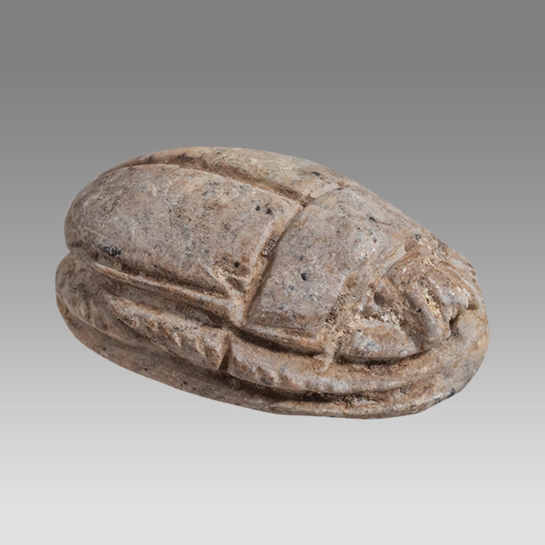 Ancient Egyptian Steatite Stone Scarab, New Kingdom c.1550-1077 BC.: Ancient Egyptian Steatite Stone Scarab, New Kingdom c.1550-1077 BC. Size 22 x 16 mm. Carved hard steatite stone scarab carved with standing facing deity at back. suspension hole through. Provenance: E