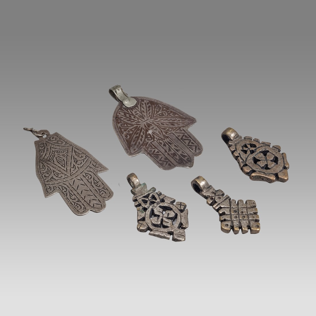 Lot of 3 Silvered Small Ethiopian Crosses, 2 Islamic Silver Amulets.: Lot of 3 Silvered Small Ethiopian Crosses, 2 Islamic Silver Amulets. Size 1 1/2 - 2 1/2 inches length. Lot of three small silvered crosses together with 2 silver Khamsa hand amulets, all with suspensi