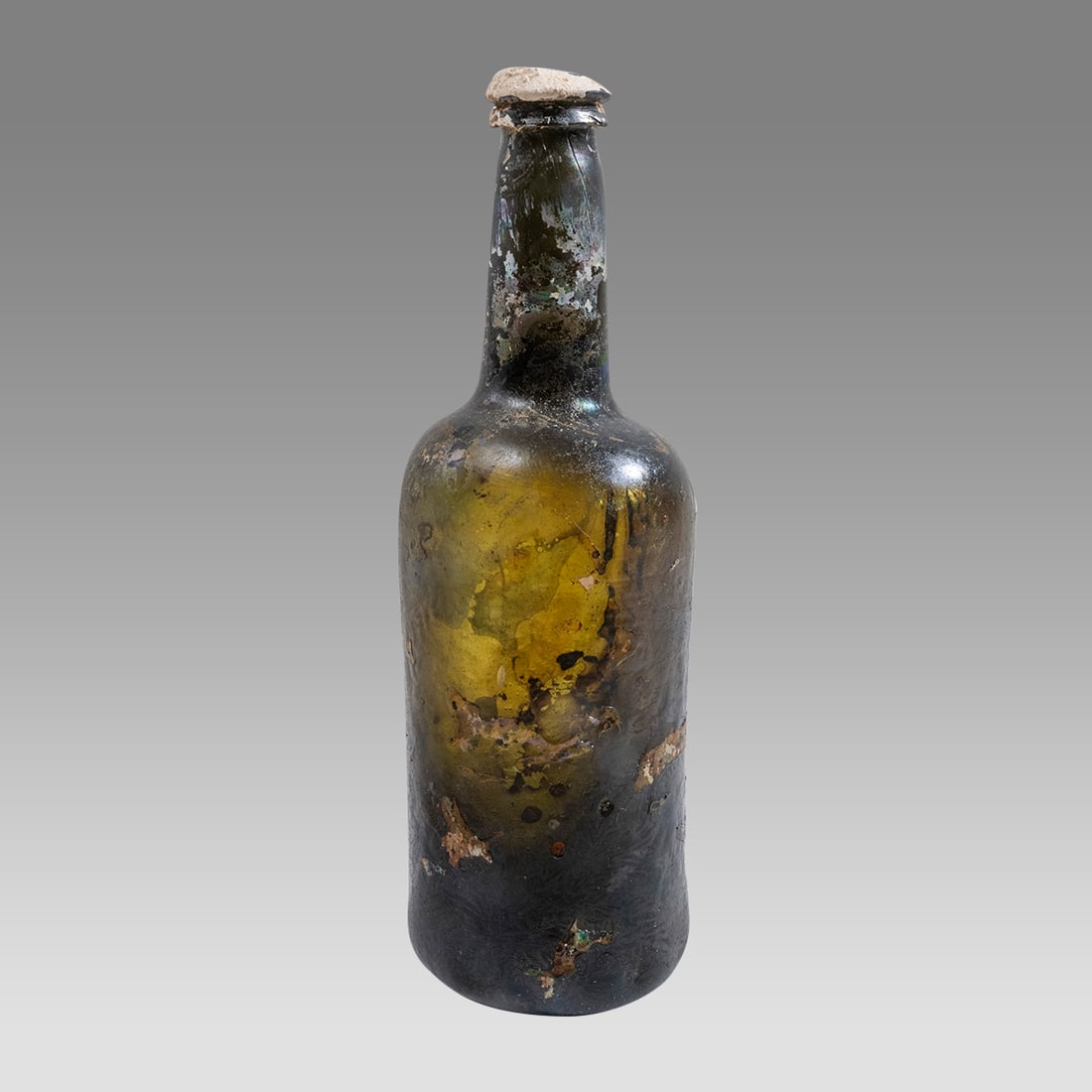 18th century North Sea Shipwreck Whisky Bottle.: 18th century North Sea Shipwreck Whisky Bottle. Size 10 3/4 inches high. A taned glass whisky bottle with sea deposit. Provenance: Ex Selim Dere private collection acquired from Chris Martin London.